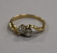 An 18ct gold and two stone diamond crossover ring, size M.