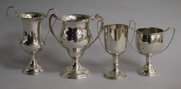 Four assorted 20th century small silver two handled trophy cups, tallest 12.5cm.