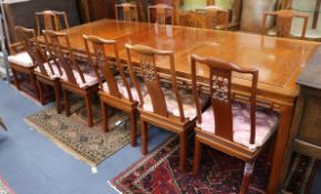 A Chinese hardwood extending dining table, with two spare leaves and a set of eleven Chinese