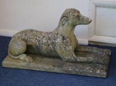 A pair of reconstituted stone recumbent dogs W.73cm