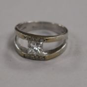 An 18ct white gold and single stone princess cut diamond ring with diamond set border, size O.