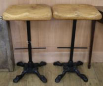A pair of cast iron base stools with oak tops W.44cm