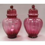 A pair of Victorian cranberry vases and covers height 32cm
