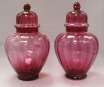 A pair of Victorian cranberry vases and covers height 32cm