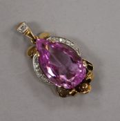 A continental yellow metal, pear cut synthetic pink sapphire and diamond pendant, overall 38mm.