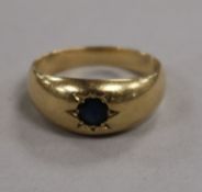 An unmarked gypsy-set ring, inset sapphire (tests as 14K gold) size O.