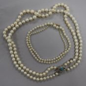 A double strand graduated cultured pearl necklace with gem set yellow metal clasp and a single