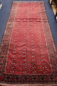 A Belouch red ground rug 310 x 135cm