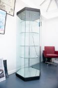 A large plate glass octagonal display case with four circular glass revolving shelves and