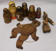 A Black Forest Bear string puppet, various Russian dolls and two carved figures