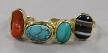 Four yellow metal and gem set rings, including banded agate and coral.