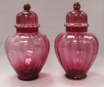 A pair of Victorian cranberry vases and covers height 32cm