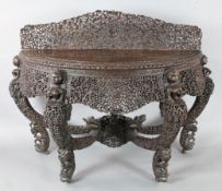 A 19th century Burmese carved hardwood console table, of demi-lune form, carved and pierced with