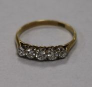 An 18ct gold and five stone diamond half hoop ring, size T.
