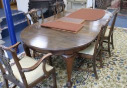 A Chippendale style circular mahogany extending dining table (three additional leaves) and a set