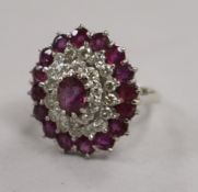 A white metal, ruby and diamond cluster dress ring, size L.