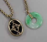 A Victorian gold overlaid and enamel locket with yellow metal chain and a jadeite disc pendant on