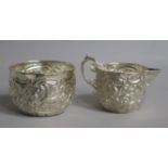 A late Victorian embossed silver cream jug and sugar bowl, Goldsmiths & Silversmiths Co, London,