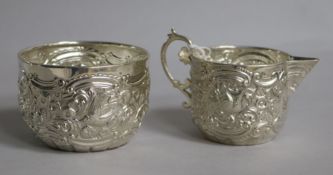 A late Victorian embossed silver cream jug and sugar bowl, Goldsmiths & Silversmiths Co, London,