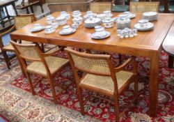 An extending dining table and six cane seated chairs W.203cm