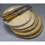 Five carved bread boards plus two carved handled bread knives and another and a bread fork largest