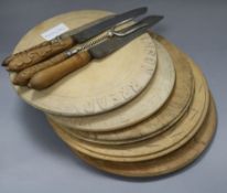 Five carved bread boards plus two carved handled bread knives and another and a bread fork largest