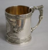 An American white metal mug decorated with flowers, makers WH, stamped sterling, c.1900-1910