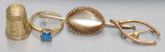 A yellow metal thimble, a gold bar brooch, a 'wishbone' brooch and a 10ct gold single stone ring (