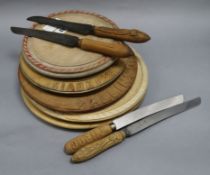 Five carved bread boards plus four carved handled bread knives largest diameter 30cm