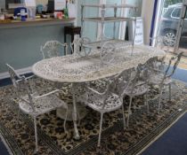 A large painted garden table with eight elbow chairs and a drinks trolley W.235cm
