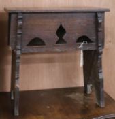 A 17th century oak Gothic style boarded stool, on trestle supports W.53cm