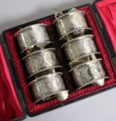 A cased set of six silver plated napkin rings and assorted small continental white metal flatware.