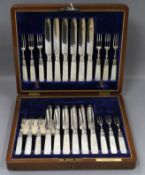 A walnut cased set of plated dessert knives and forks, with mother of pearl handles