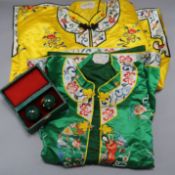 Two Chinese silk embroidered jackets with two Chinese musical enamelled balls, cased