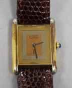 A lady's silver gilt Must de Cartier tank wrist watch, with blue cabochon winder