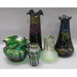 A Loetz style lobed iridescent green wavy rim vase and four other glass vases, including a small