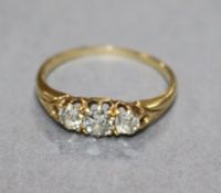An early 20th century yellow metal and three stone diamond ring, size O.