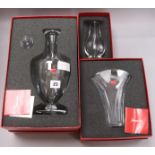 A Baccarat decanter and two vases, all cased decanter height 34.5cm