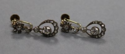 A pair of early 20th century yellow metal and diamond open work drop earrings, 23mm.