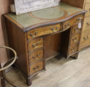 A mahogany serpentine kneehole desk W.91cm