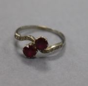 An early 20th century white metal, two stone ruby crossover ring, with diamond set shoulders, size