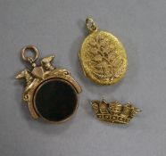 A Victorian 9ct gold and carnelian set spinning fob seal, a 9ct coronet brooch and a yellow metal