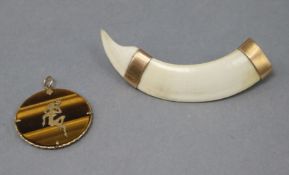 A gold mounted tiger's eye pendant, 4cm and a gold mounted tusk brooch 9cm