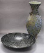 A studio pottery tall stoneware vase and a black soapstone charger, the vase of bulbous form on