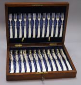 A set of twelve late Victorian plated engraved dessert knives and forks, with mother of pearl pistol