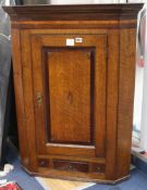 A late 18th century oak and mahogany banded hanging corner cupboard W.76cm