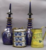 A pair of Egyptian dark blue glass decanters and stoppers, a Chinese blue and white metal mounted