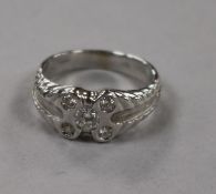 An 18ct white gold and collet set five stone diamond dress ring, size L.