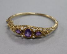 A 1970's Victorian style amethyst and seed pearl hinged bangle,