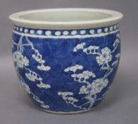 A Chinese blue and white jardiniere decorated with prunus, four-character mark to base, H 19.5cm